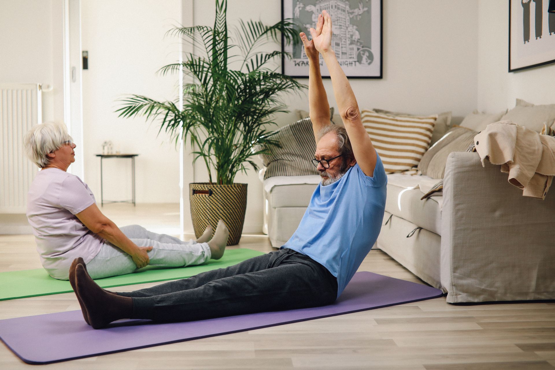 An elderly couple doing gentle yoga together at home